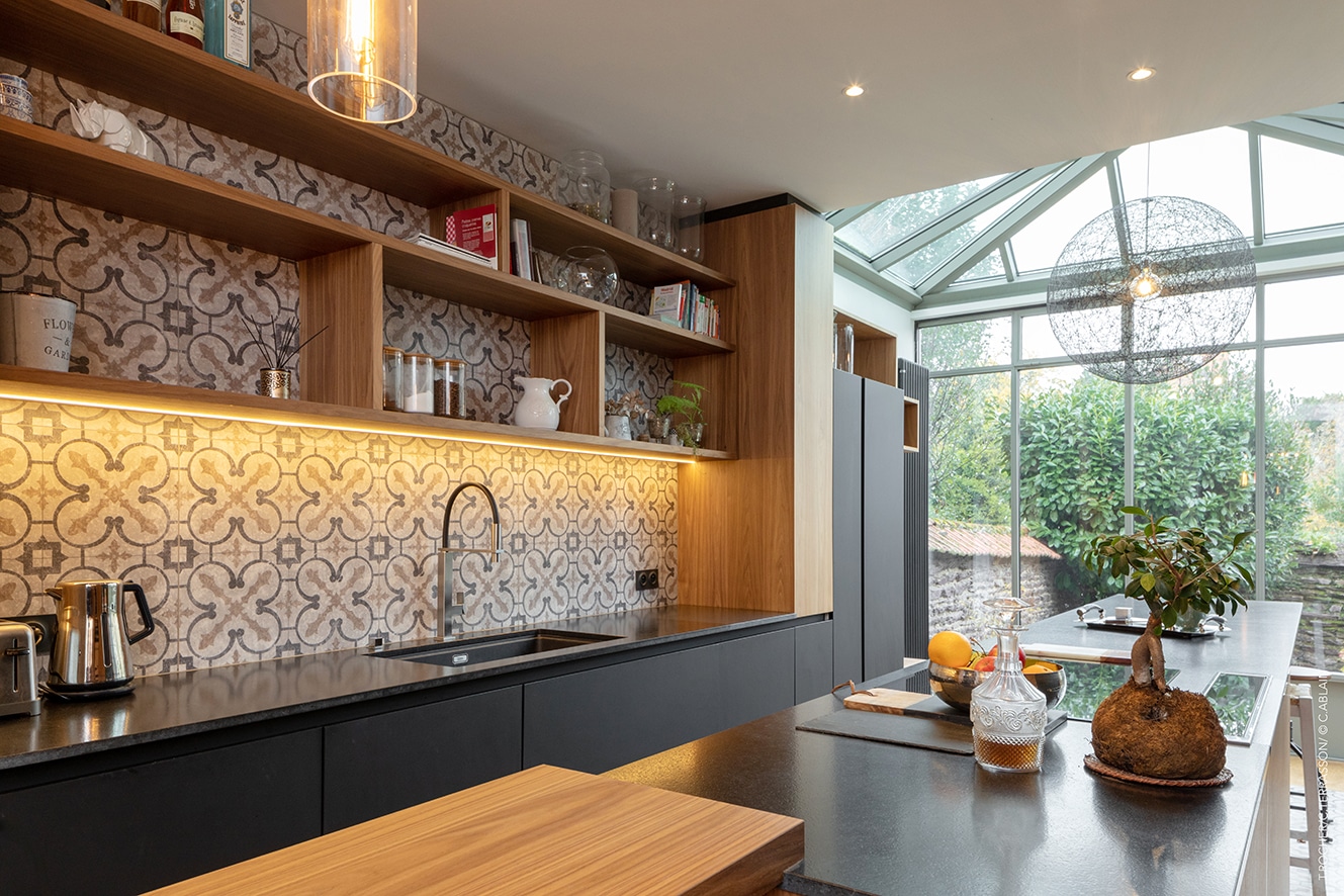 Rénovation de cuisine avec parquet de chêne, placage en noyer, plan de travail en granit noir et plafond en staff