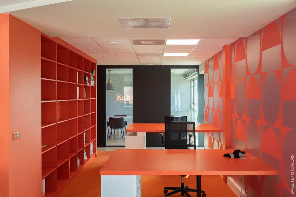 Conception de bureaux pour Bakelite Architecture. Décoration d'intérieur dans les tons orange. Moquette, flotex, stratifiés, lettres néons, luminaire industriel, carrelage effet bois, ruban led