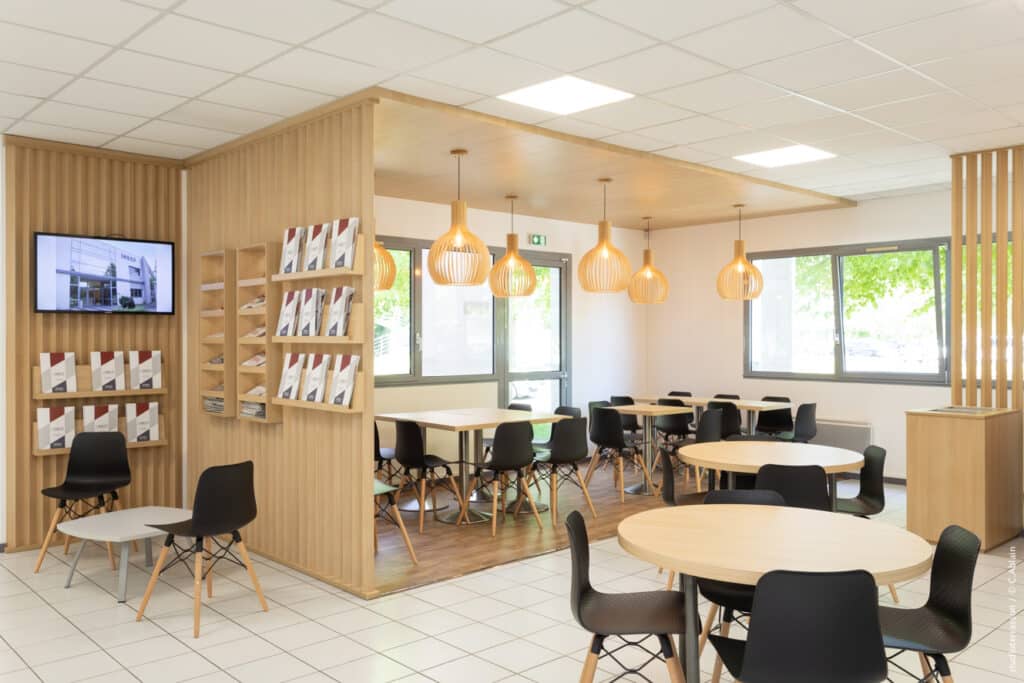 Conception de locaux pour My Digital School. Claustra bois, plafond bois luminaire bois, sol effet bois. Cafétéria et espace documentation