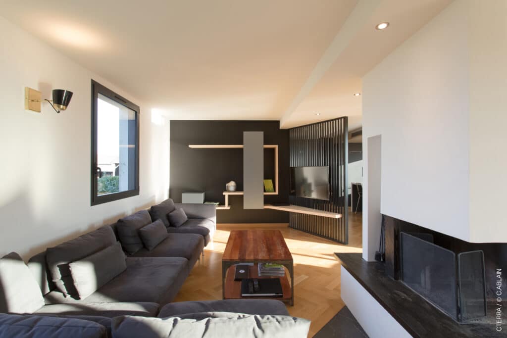 Rénovation de salon dans maison néo-bretonne, Faux-plafond en lames stratifiées sur ossature métallique, Parquet chêne massif pose à bâtons rompus ; ilôt de carrelage 60×60 gris anthracite,