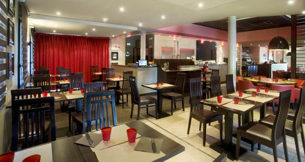 Conception de restaurant à Fougères, décoration de restaurant, carrelage ton bois, plafond tendu, banquette simili cuir, carrelage rouge, terrasse, mobilier extérieur, rideau rouge, plafond dalles acoustiques, stores