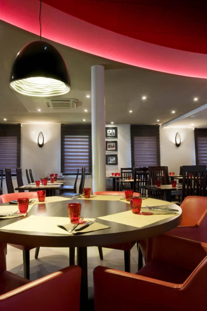 Conception de restaurant à Fougères, décoration de restaurant, carrelage ton bois, plafond tendu, banquette simili cuir, carrelage rouge, terrasse, mobilier extérieur, rideau rouge, plafond dalles acoustiques, stores